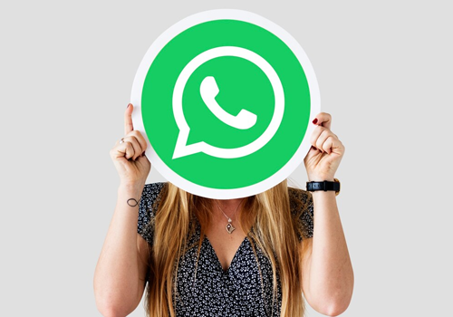 Mulher com logo do aplicativo WhatsApp no rosto.